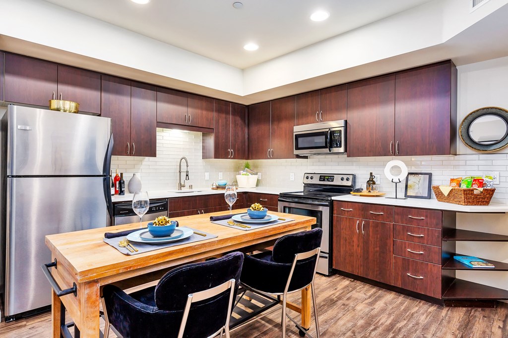 a kitchen with stainless steel appliances and a wooden table