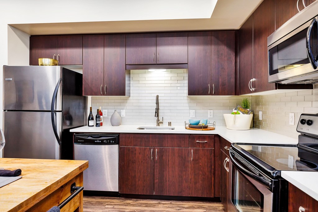 a kitchen with wooden cabinets and stainless steel appliances