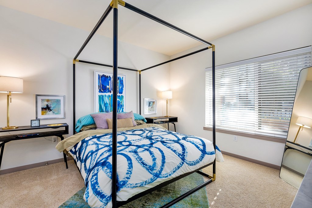 a bedroom with a four poster bed and a large window