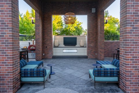 A patio with a couch and a television set.