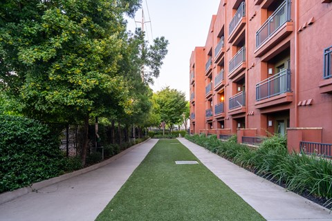 A long grassy area in front of apartment buildings.