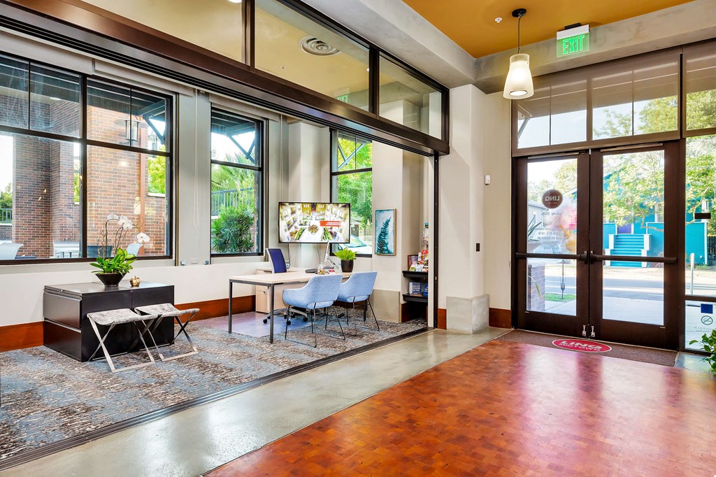 a lobby with a table and chairs and a large window