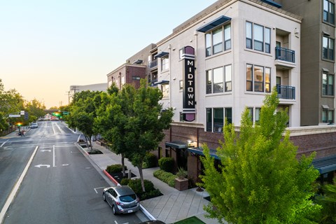 A street view of a residential area with a car parked on the side of the road.