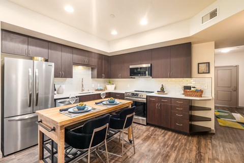A modern kitchen with a dining table set for two.