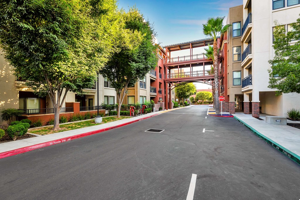 an empty street with buildings on both sides and a bridge