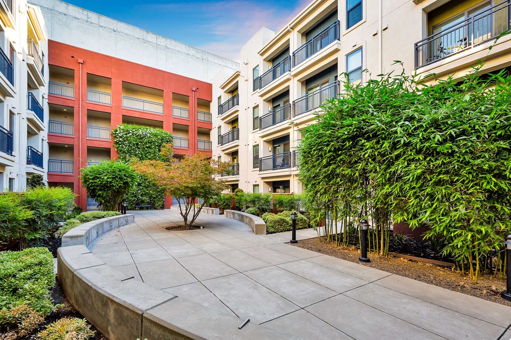 an apartment building with a walkway and trees in front of it