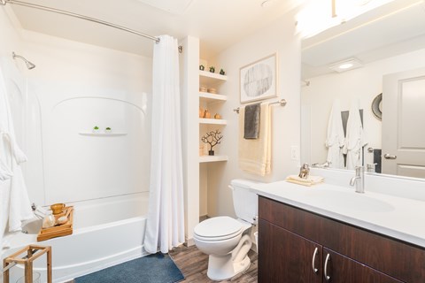 A white bathroom with a toilet, sink, and bathtub.