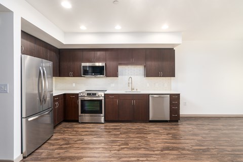 A modern kitchen with wooden cabinets and stainless steel appliances.