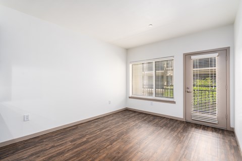A room with a wooden floor and a sliding glass door.