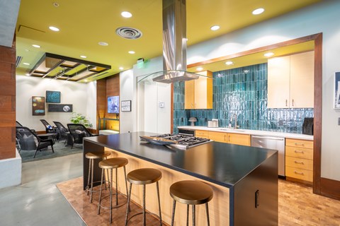 A modern kitchen with a long island and stools.