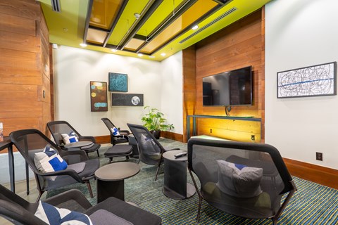 A room with a yellow ceiling and a wooden wall with a TV and a plant.