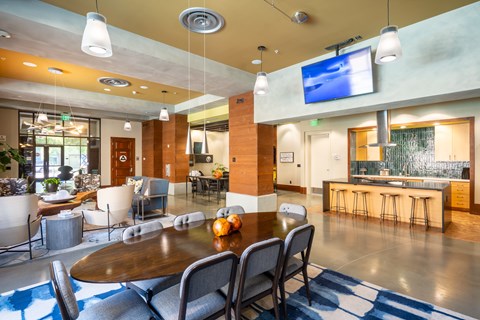 A modern dining room with a wooden table and grey chairs.