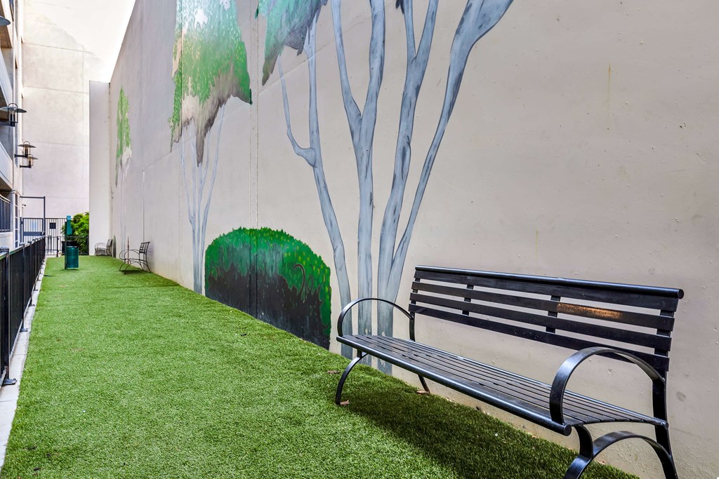 a park bench in front of a wall with a mural
