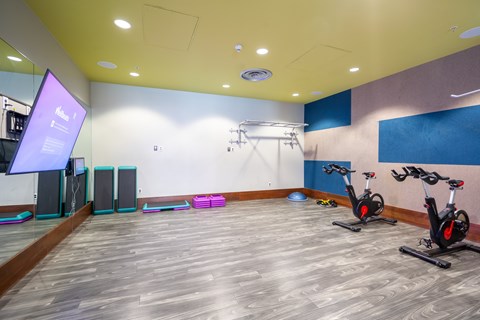A gym with exercise bikes and a screen.