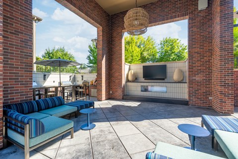 A patio with a brick wall and a television.