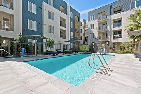 A swimming pool in front of apartment buildings.