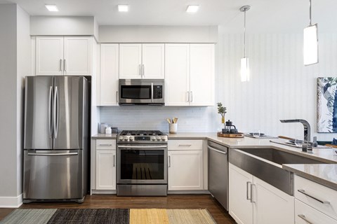 a kitchen with white cabinets and stainless steel appliances