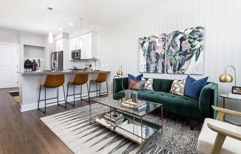 A modern living room with a green couch and a glass coffee table.