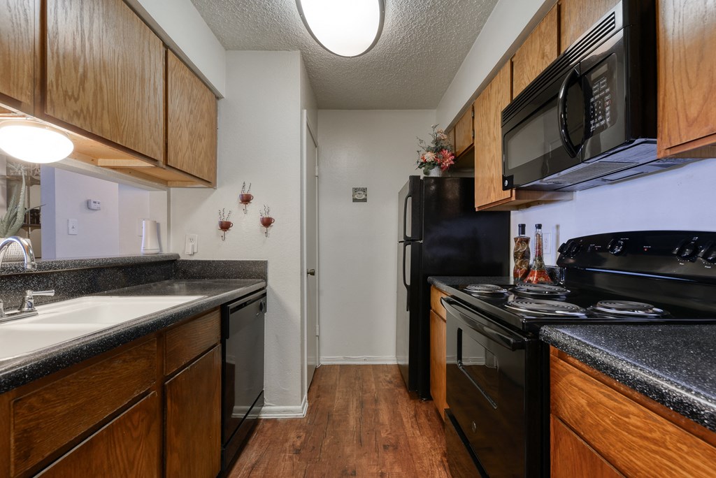 a kitchen with black appliances and wood cabinets