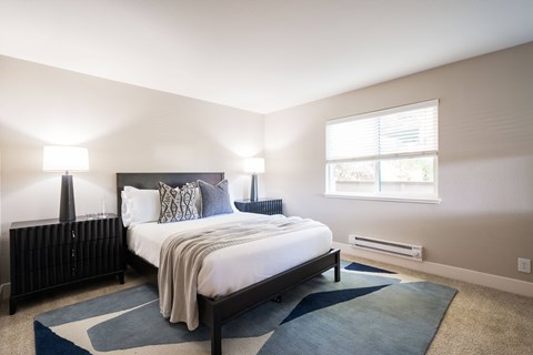 A bedroom with a large bed and a window.