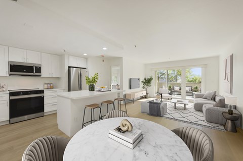 A modern kitchen with a marble table and bar stools.