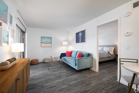 A living room with a blue couch and a wooden cabinet.