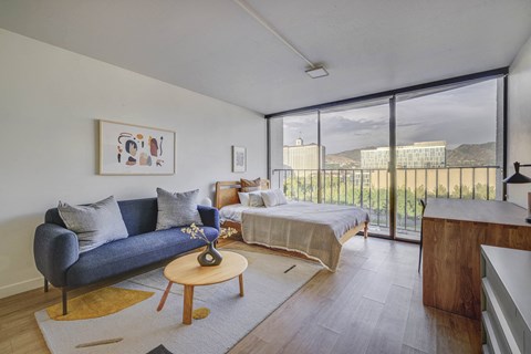 a living room with a couch and a bed and a balcony