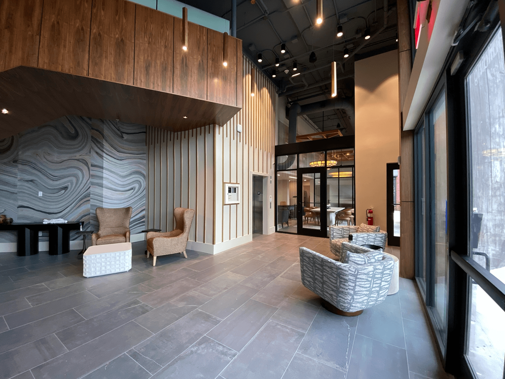 the lobby of a building with chairs and a table