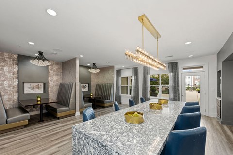 A modern dining room with a marble table and blue chairs.