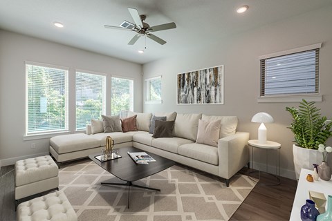 a living room with a white couch and a ceiling fan