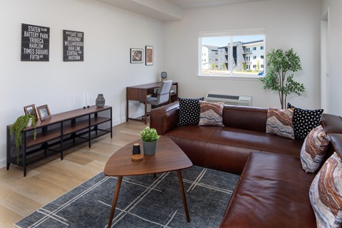 A living room with a brown leather couch and a wooden coffee table at The Arvon, Vancouver