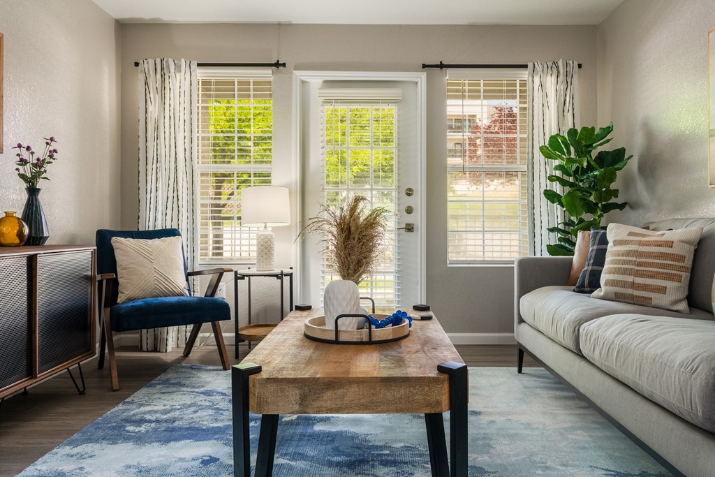 a living room with a couch chair and coffee table  at Odyssey Apartments, Albuquerque, NM