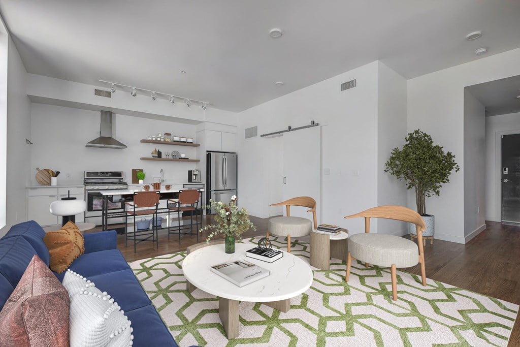a living room with a blue couch and a green and white rug