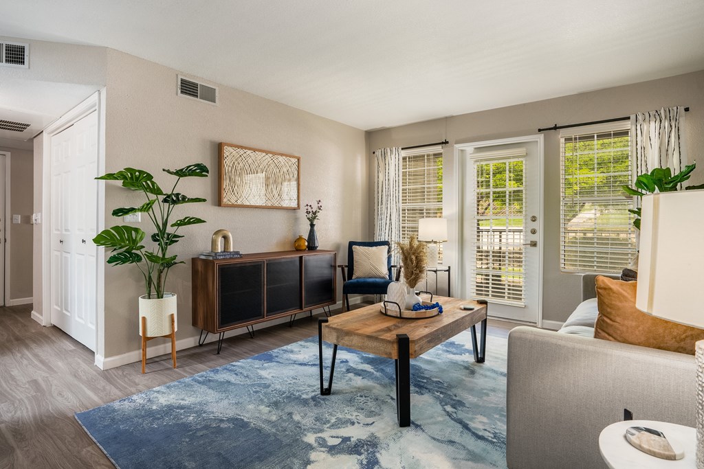a living room with a couch coffee table and a tv  at Odyssey Apartments, Albuquerque, 87114