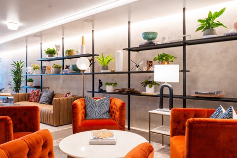 a living room with orange chairs and a white table