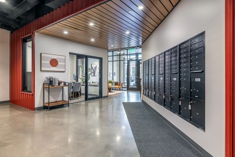 A long hallway with a row of mailboxes on the wall.