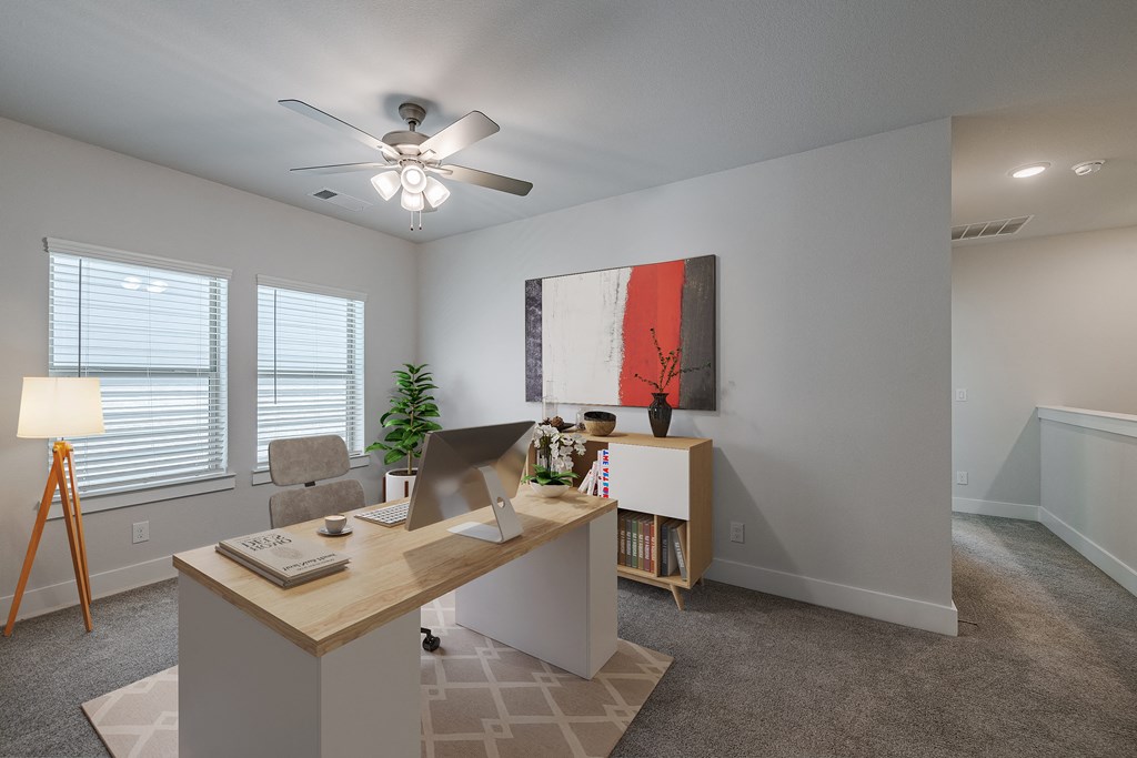 an office with a desk and a ceiling fan