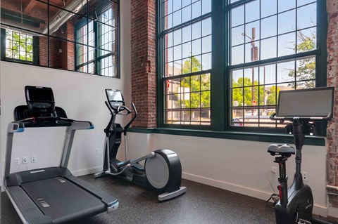 Fitness center with treadmill, elliptical, and cycling bike.