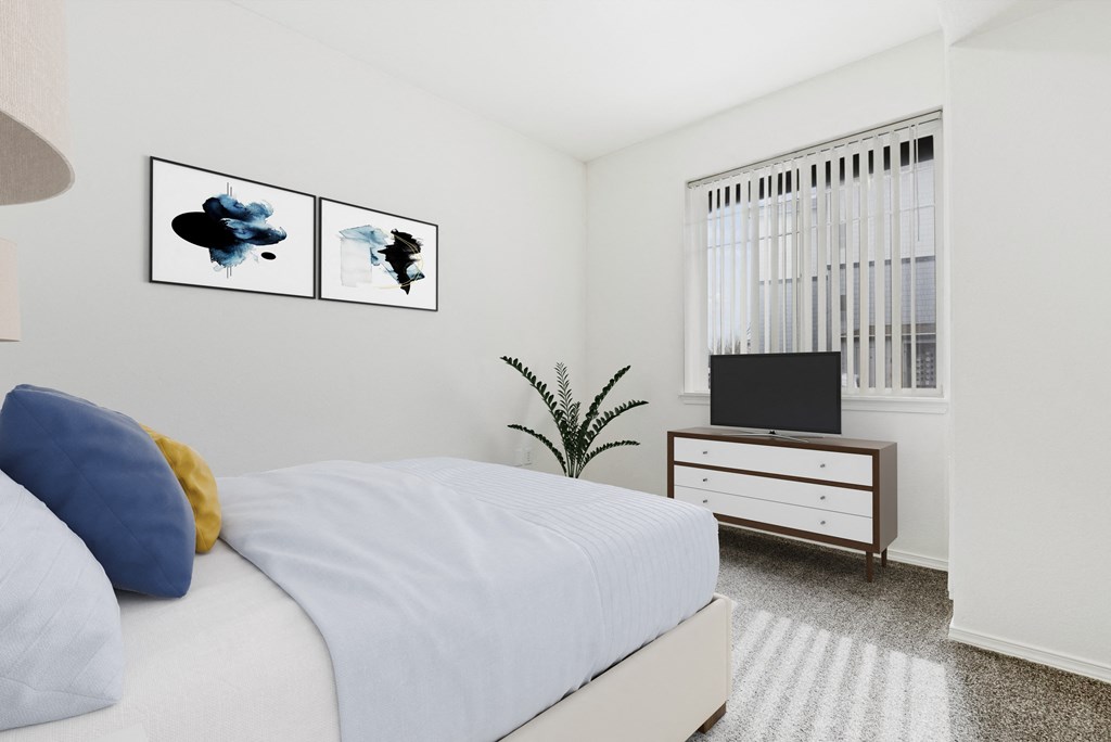 A bedroom with a bed, a television, and two framed pictures on the wall.
