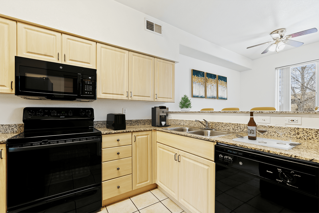 A kitchen with black appliances and wooden cabinets.