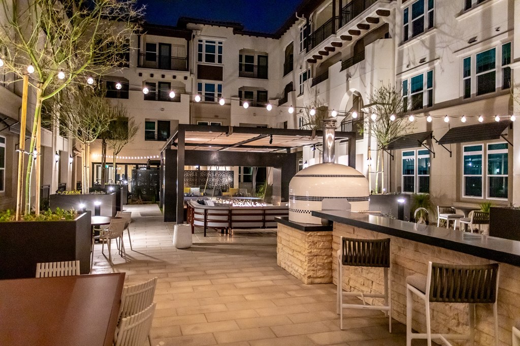 A patio area with a bar and chairs.