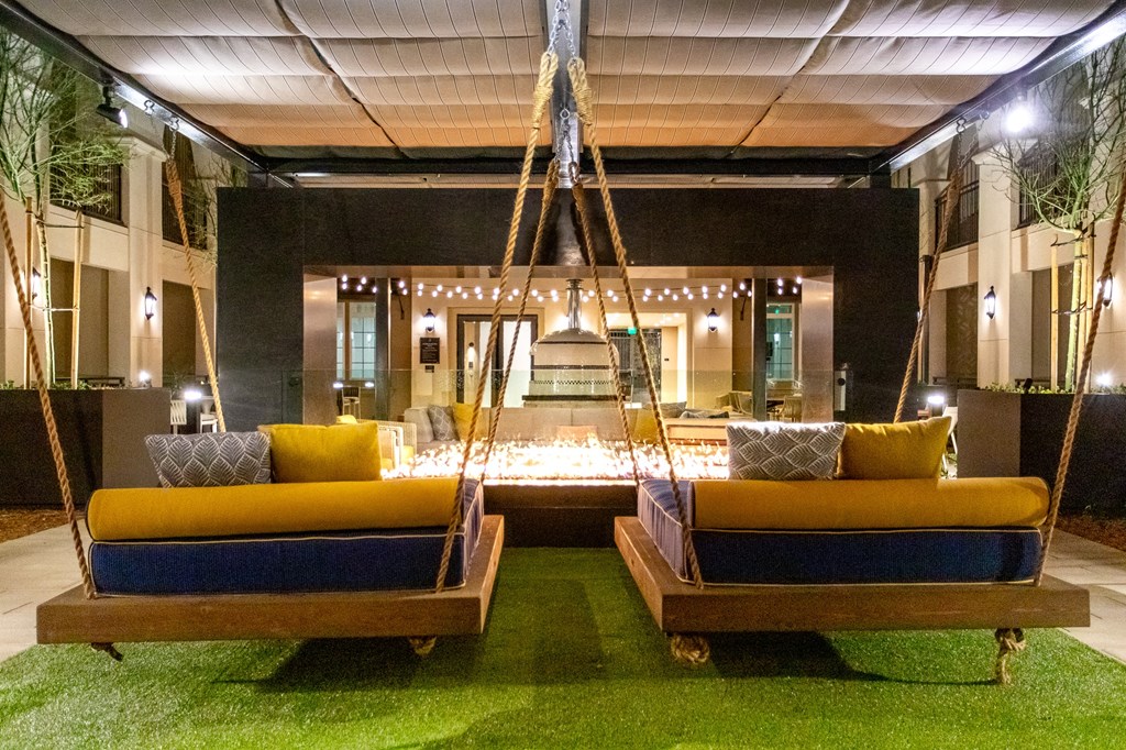 A room with two hanging beds and a swing.