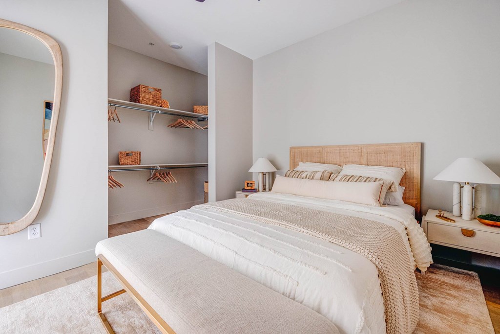 A bedroom with a large bed and a mirror on the wall.