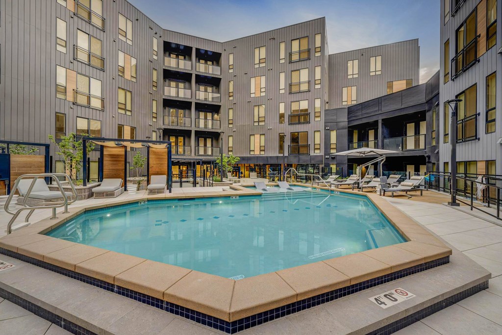 A large swimming pool in the middle of a courtyard surrounded by buildings.