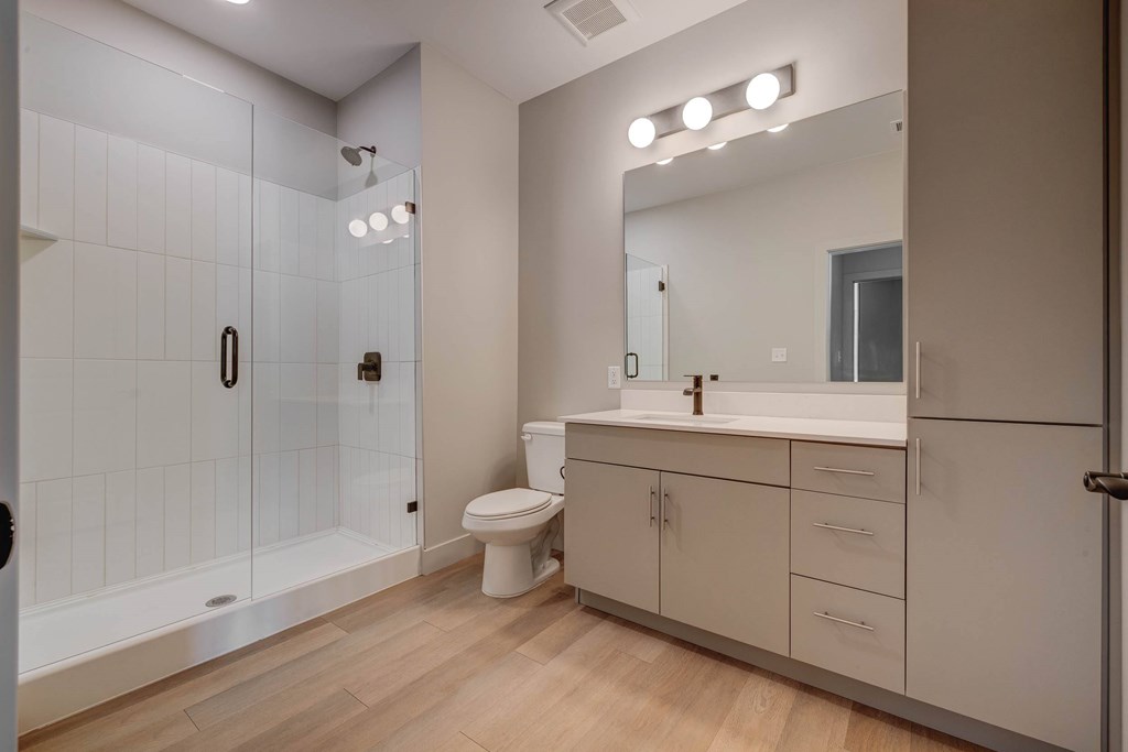 A bathroom with a toilet, sink, and shower.