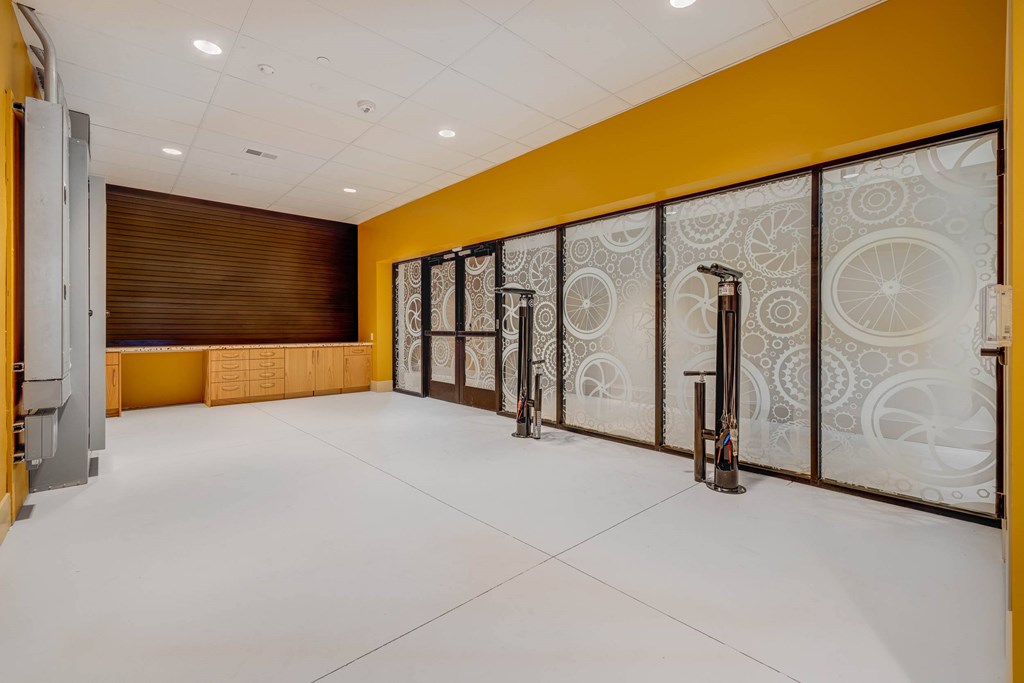 A hallway with a yellow wall and white floor.