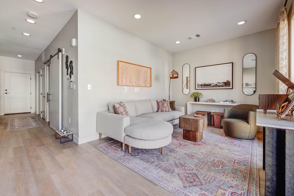 A living room with a white couch and a rug.