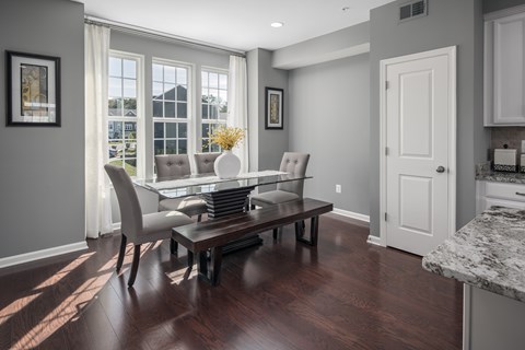 A dining room with a table and chairs.
