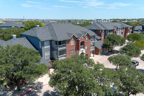 A bird's eye view of an apartment building surrounded by trees at The Quarry Alamo Heights Apartments, San Antonio, TX, 78209