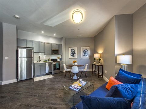 a living room and kitchen with a couch and a table